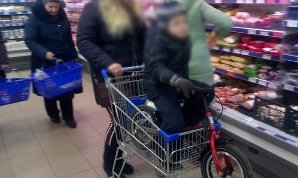 Днепрянка посадила ребенка на велосипеде в магазинную тележку
